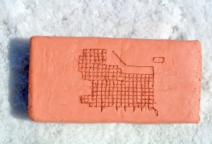 clay brick with the 1860 Zion Plat etched into it. it is sitting on the salt crust of the salt flats. 
