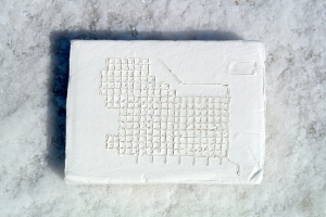 White brick with the 1860 Zion Plat etched into it. it is sitting on the salt crust of the salt flats. 