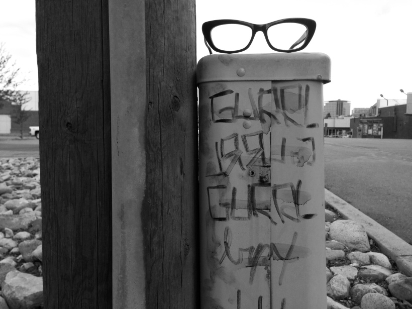 A pair of cateye glasses atop a pole that reads GURRL