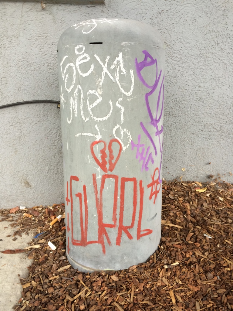 Graffiti tag that reads GURRL with a broken heart above it. All in lipstick red.